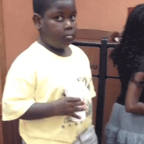 Black Kid Holding A Cup Giving the Awkward Eye